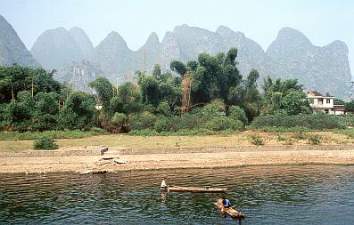 Karsthügellandschaft am Li-Fluß zwischen Zhujiang und Yangshuo, vorne Bauern mit ihren Bambusflossen