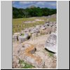 Kabah - Ostgruppe der Maya-Ruinen, Blick vom Tempel der Masken aus nach Nordwesten, vorne abgebrochene Rüsselnasen und andere Fassadenteile, hinten die Große Pyramide