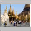 Yangon - Shwedagon Pagode, Nordseite des Zentralstupas (hinter dem Gerüst), in der Mitte die Gautama-Buddha-Gebetshalle, vorne eine Putzkolonne