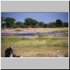 Etosha N.P. - Landschaft mit einer Wasserstelle, im Hintergrund zwei Giraffen