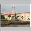 Blick vom Boat Quay auf die gegen&uuml;berliegende Seite des Singapur Rivers, von links: Parlamentsgeb&auml;ude, Raffles-Denkmal (klein), Empress Place Building, hinten der Uhrturm vom Victoria Theatre & Concert Hall