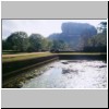 Sigiriya - Felsen mit der Ruine der Bergfestung (Westseite), davor ein Wasserbecken in der Gartenanlage