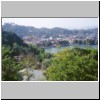 Kandy - Blick von einem Aussichtspunkt im Süden der Stadt auf das Zentrum mit dem See Muhada Wewa (Kandy Lake), links auf einem Berg - der sitzende Buddha