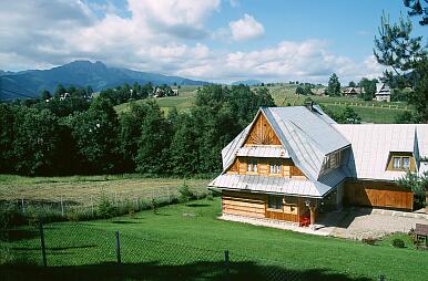 Zakopane - Stadteil Olcza-Stachonie, Blick nach Südwesten auf die Tatra; vorne ein typ. Haus, hinten links der Berg Giewont