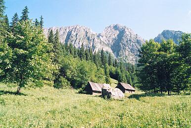 Unterwegs von Giewont runter ins Tal Dolina Strazyska; Blick von der Wiese Polana Strazyska nach Süden auf den Berg Giewont, vorne Hirtenhütten und ein Felsen genannt Sfinx