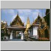 Bangkok - Wat Phra Kaeo, links ein Yak-Dämon am Tempeleingang, hinten dem Pavillon eine Bronzestatue eines berühmten Arztes, daneben Hor Rajbongsanusorn, rechts der Bot (Tempel des Shmaragdbuddhas), hinten goldener Phra Sri Ratana Chedi