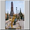 Bangkok - Wat Phra Kaeo, ein goldener "Kinara" (mythisches Fabelwesen), dahinter ein Prang an der &ouml;stlichen Begrenzung des Wat sowie eine D&auml;monfigur am &ouml;stlichen Eingang