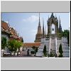 Bangkok - Wat Pho, ein Glockenturm im Eingangsbereich, dahinter die 4 großen porzellangeschmückten Chedis