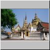 Bangkok - Wat Pho, die mit Porzellan dekorierte Bibliothek, dahinter große Chedis