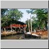 Damnoen Saduak - unterwegs durch die Klongs, Vegetation und Bebauung am Ufer