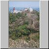 Petchaburi - Blick vom "Bergschloss" auf die Nachbarhügel (u.a. alte Chedis und rote Pagode), vorne weiß blühende Frangipani-Bäume