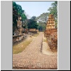 Sukhothai - die Ruinen von Wat Mahathat, links eine Buddhastatue
